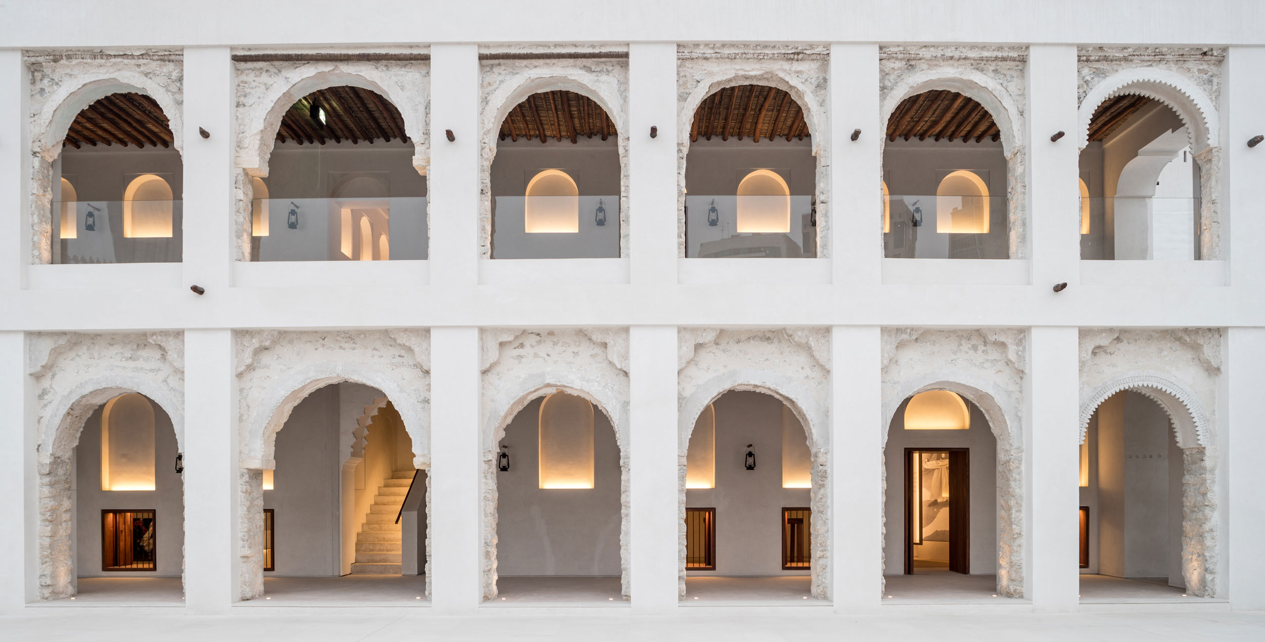 Restored heritage building in Abu Dhabi with traditional arches, textured walls, and warm lighting