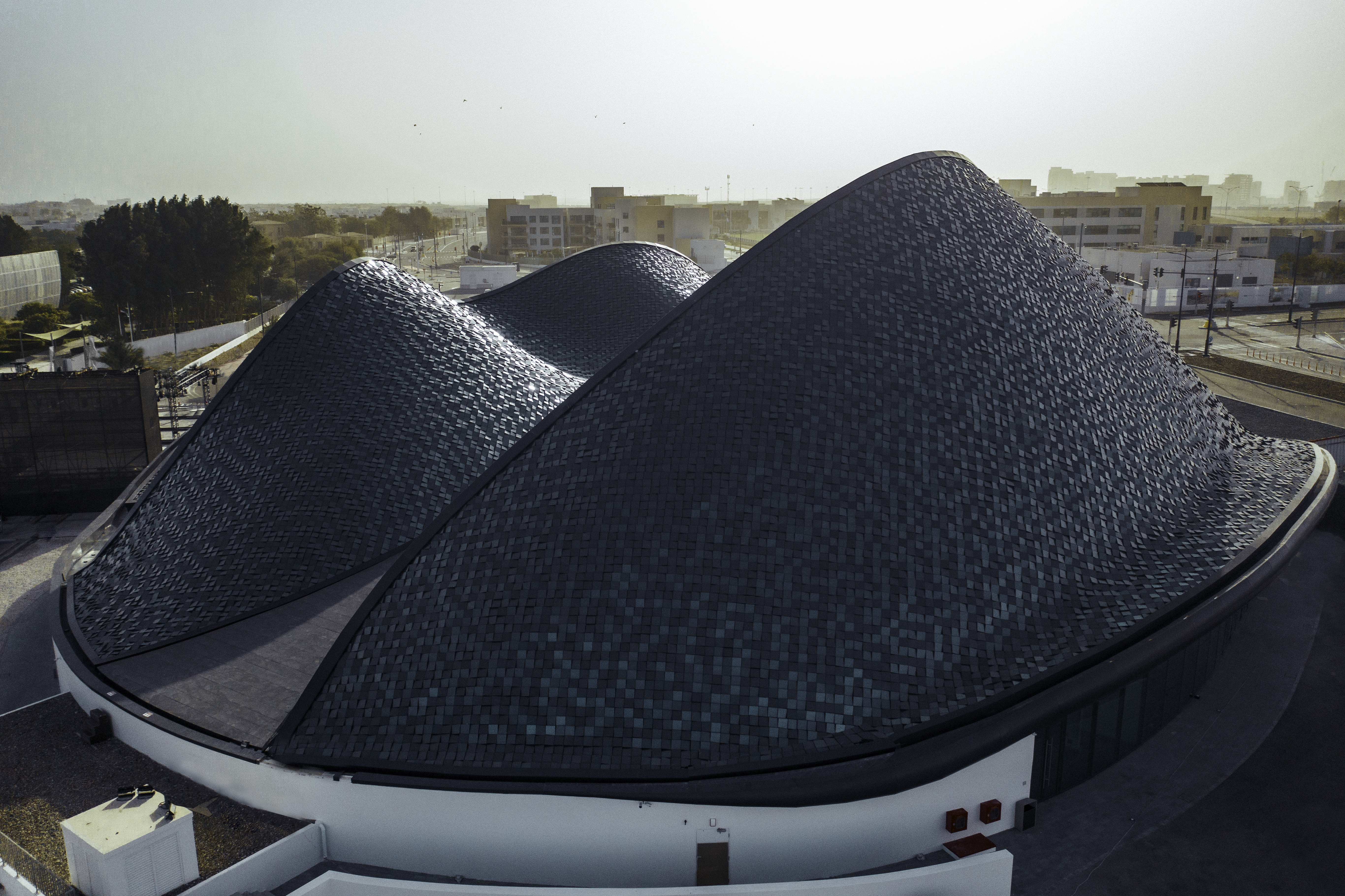  Un bâtiment moderne aux formes organiques, symbolisant l'innovation d'Abu Dhabi, se dresse magnifiquement sous le ciel clair.