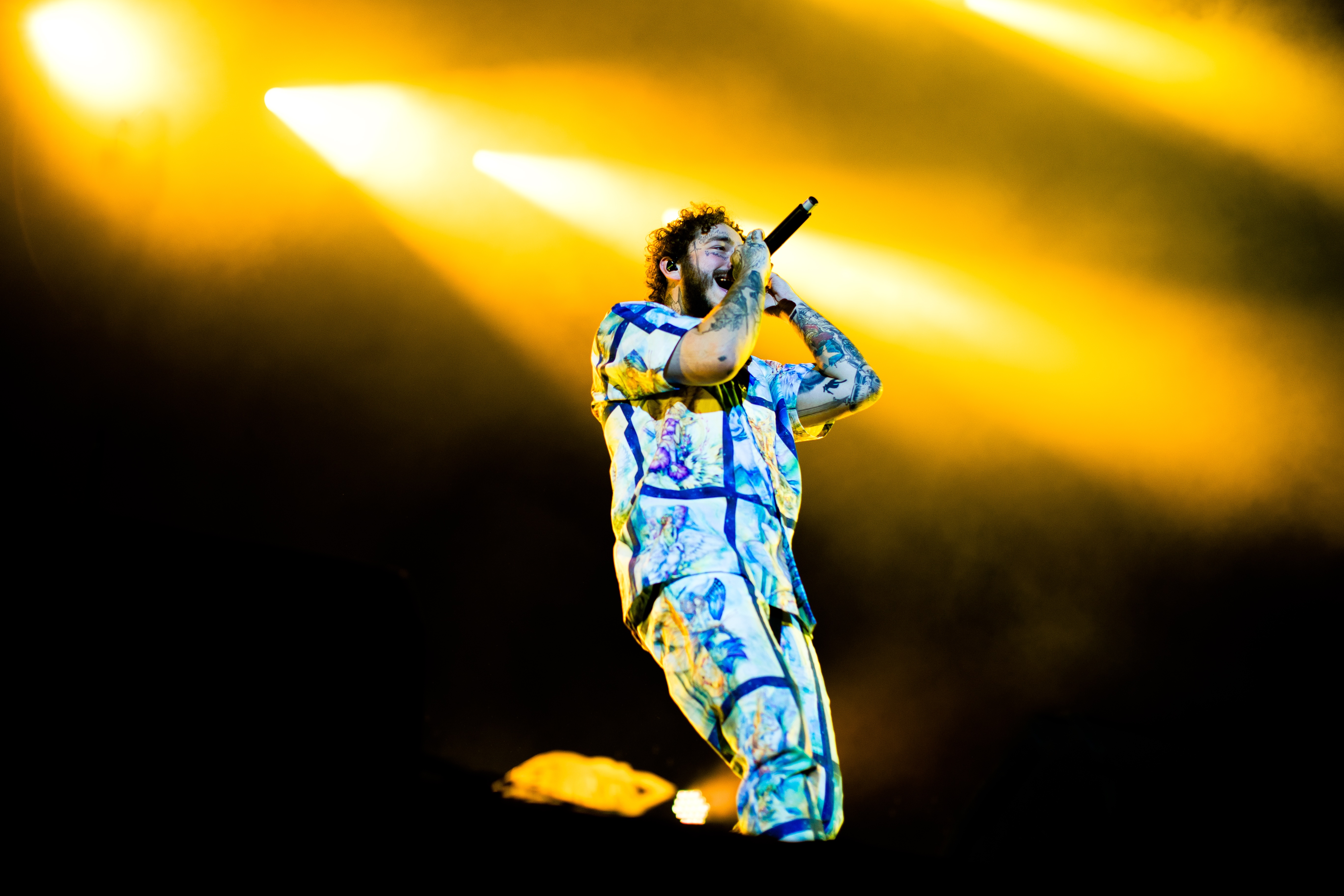 Il cantautore Post Malone in un evento dal vivo ad Abu Dhabi sotto luci gialle intense
