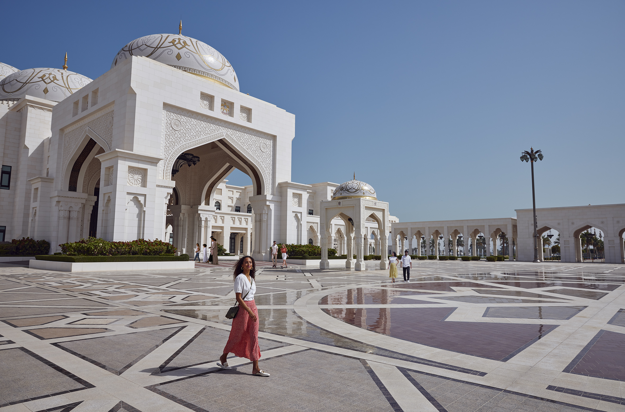 Turisti passeggiano nel cortile del Palazzo Presidenziale Qasr Al Watan, luogo di riferimento per il patrimonio culturale di Abu Dhabi dalla classica architettura islamica