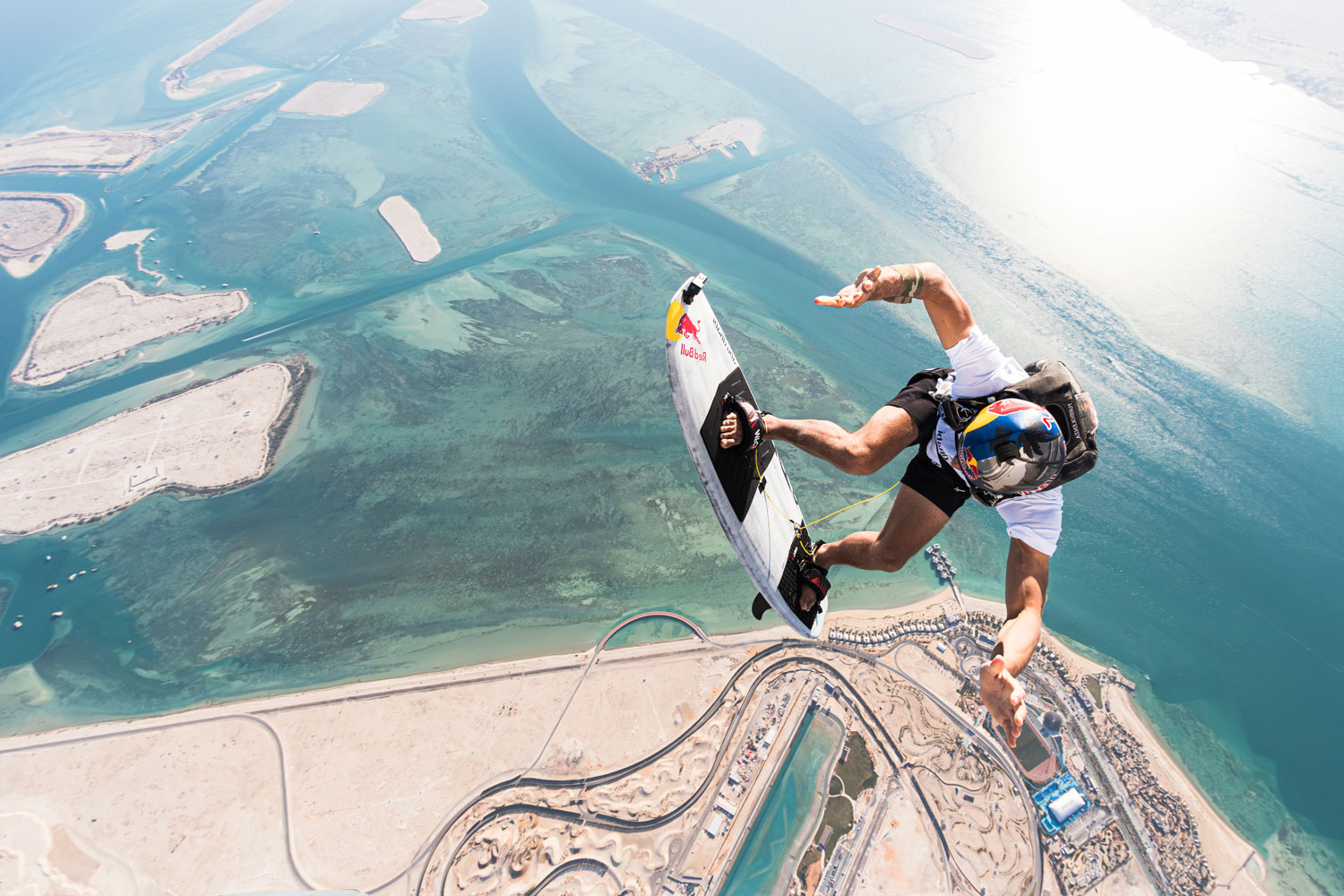 "Skydiver performing aerial tricks with a board above the Abu Dhabi coastline and islands. "